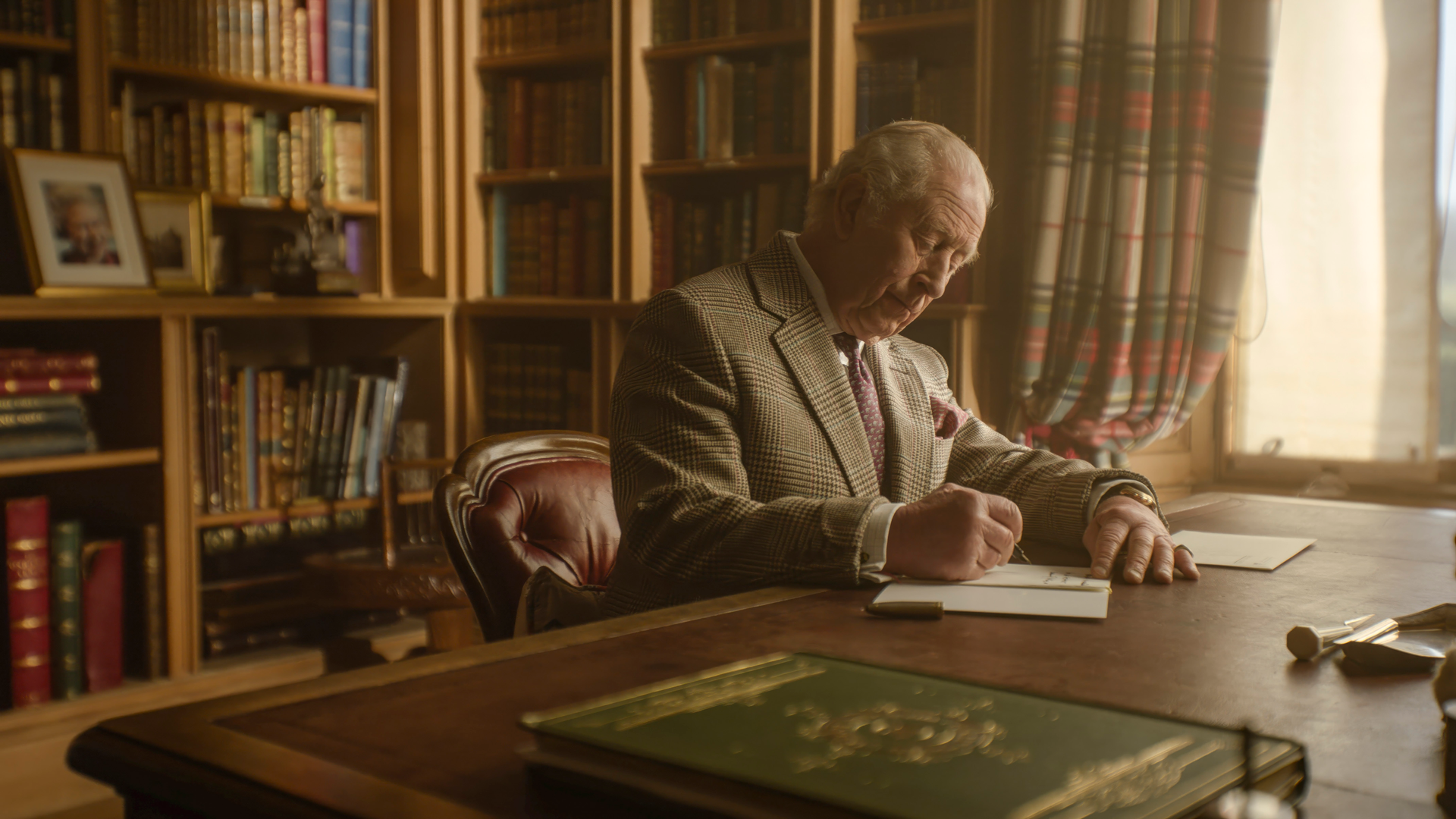 King Charles sitting at desk in Balmoral Castle
