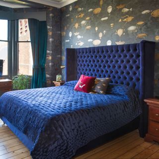 Bedroom with king bed, blue quilt and headboard