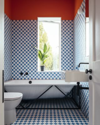Bathroom with checkered walls and white tub.