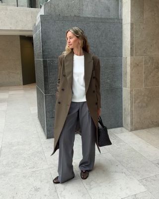 Fashion influencer Anouk Yve in Europe wearing a chic fall outfit styled with mesh flats.