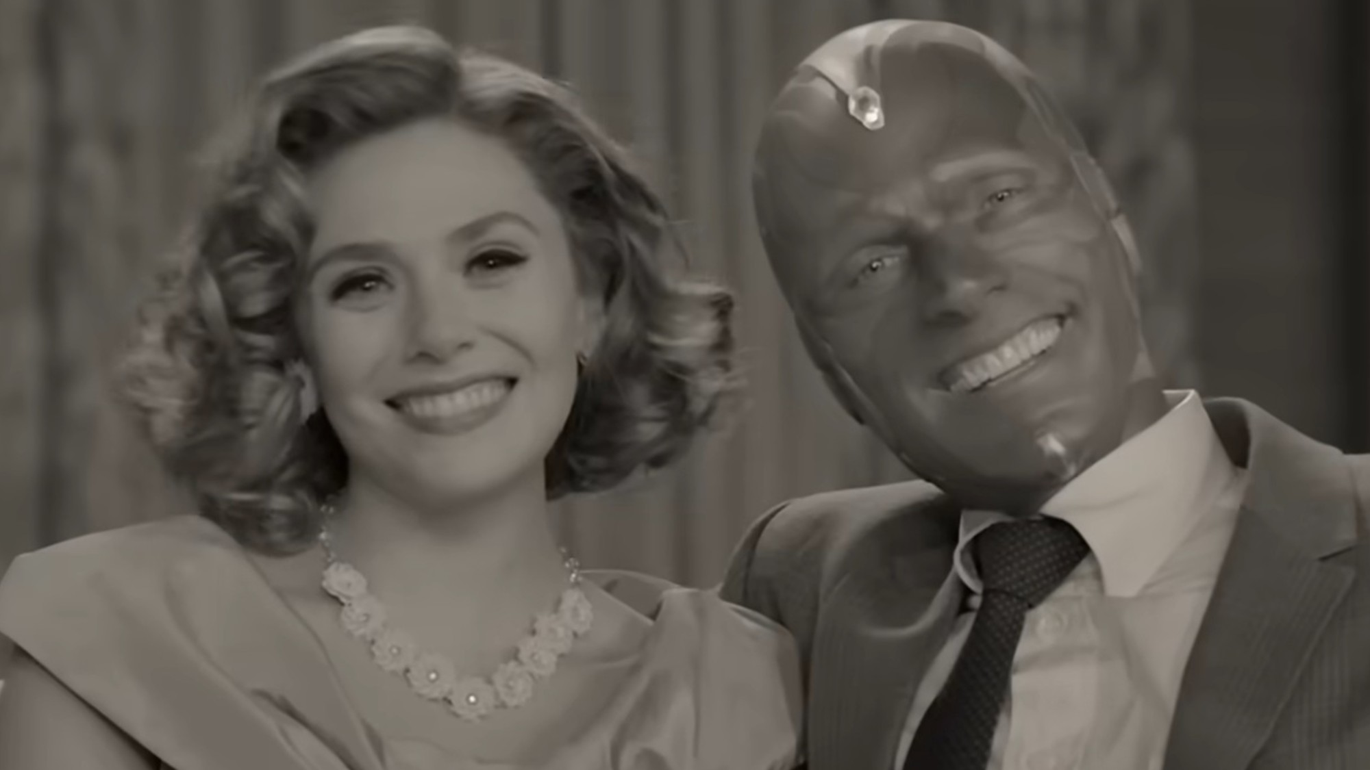 Elizabeth Olsen and Paul Bettany smiling on a couch in WandaVision