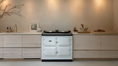 A white aga oven in a neutral wooden kitchen