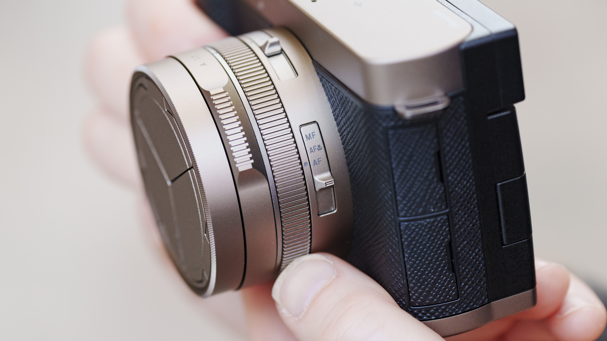 Man holding the Panasonic Lumix L10 compact camera in an urban setting of Japan