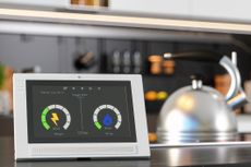 Smart meter and energy prices on blurred kitchen background