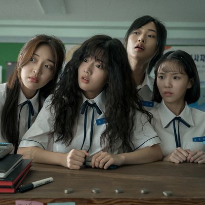 four school girls including in uniform including Shin Eun-soo as Park Se-ri sit at a desk and look to the right in a still from the movie love untangled