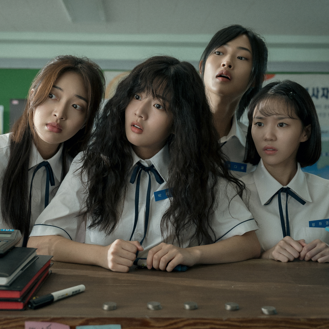 four school girls including in uniform including Shin Eun-soo as Park Se-ri sit at a desk and look to the right in a still from the movie love untangled