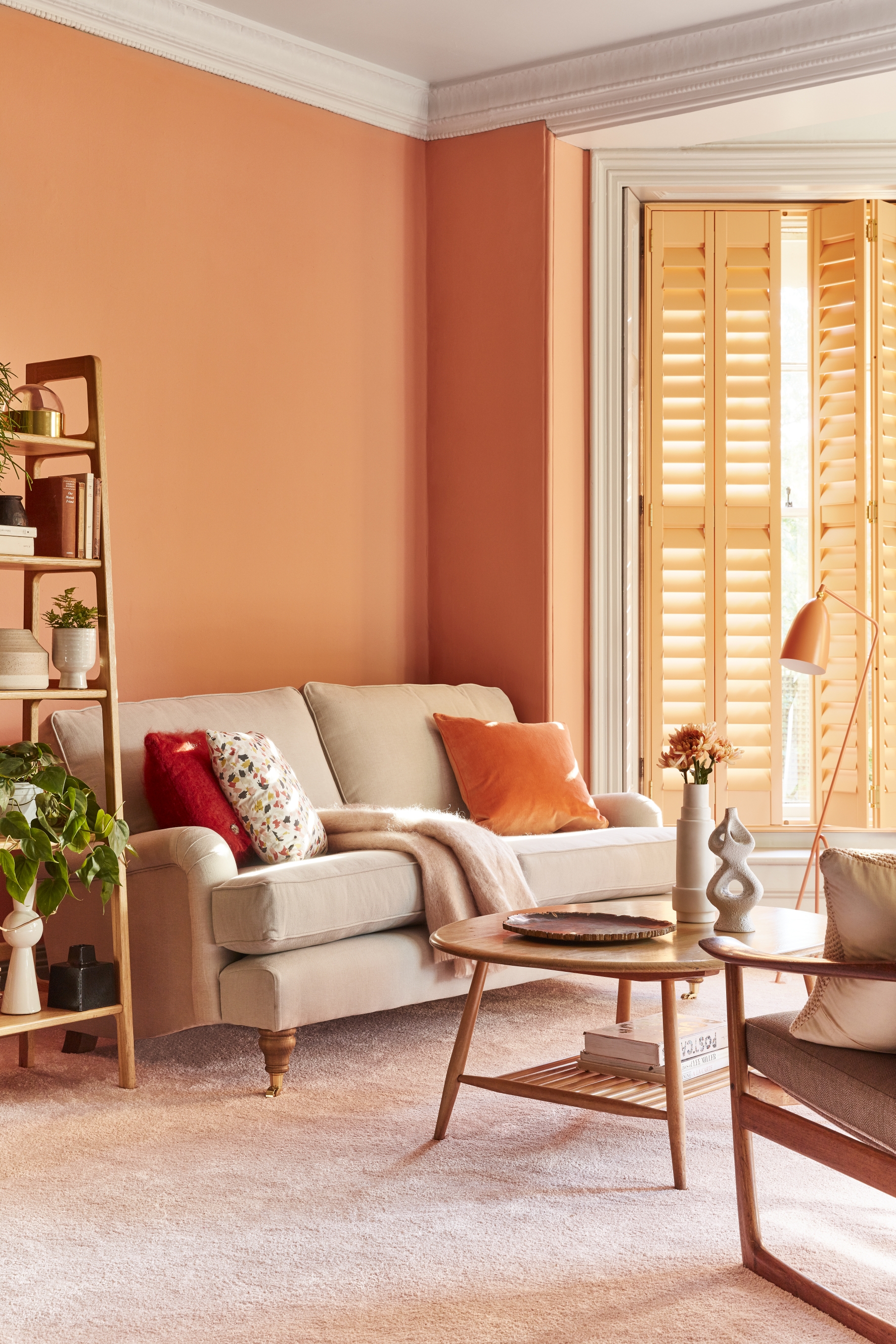 A coral living room paint color idea with shutters by California Shutters