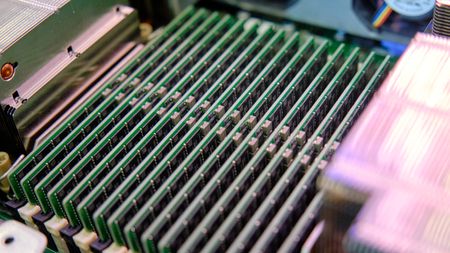 A stock photo of a computer motherboard with multiple memory slots filled with DRAM DIMMs for High Performance Computing (HPC)