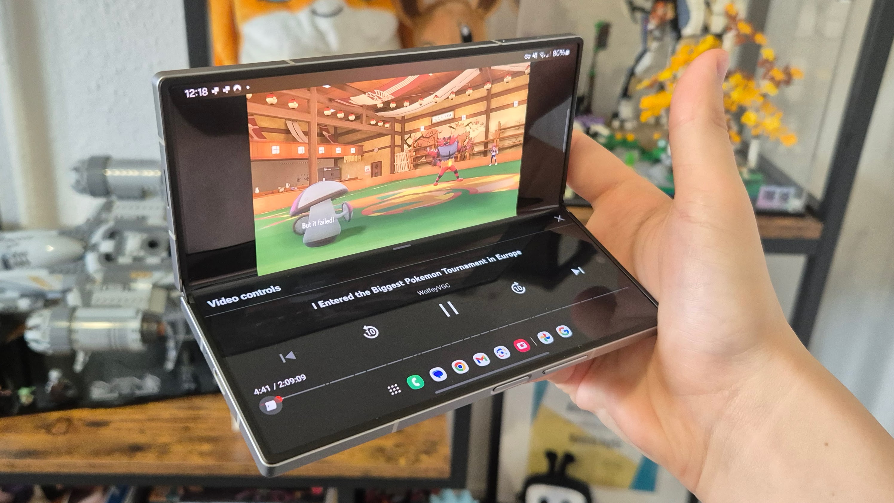 Une vidéo YouTube montrant Amoonguss de Pokémon sur un Z Fold 6, il est partiellement plié et sur la moitié inférieure de l'écran se trouvent les commandes vidéo
