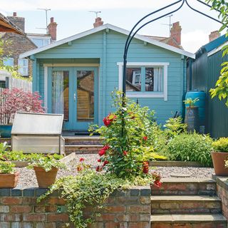 garden area with blue painted summer house