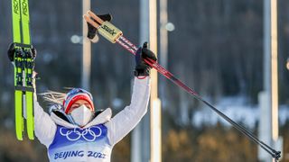 Therese Johaug poserer under blomsterseremonien etter å ha vunnet skiathlon under Beijing 2022-lekene