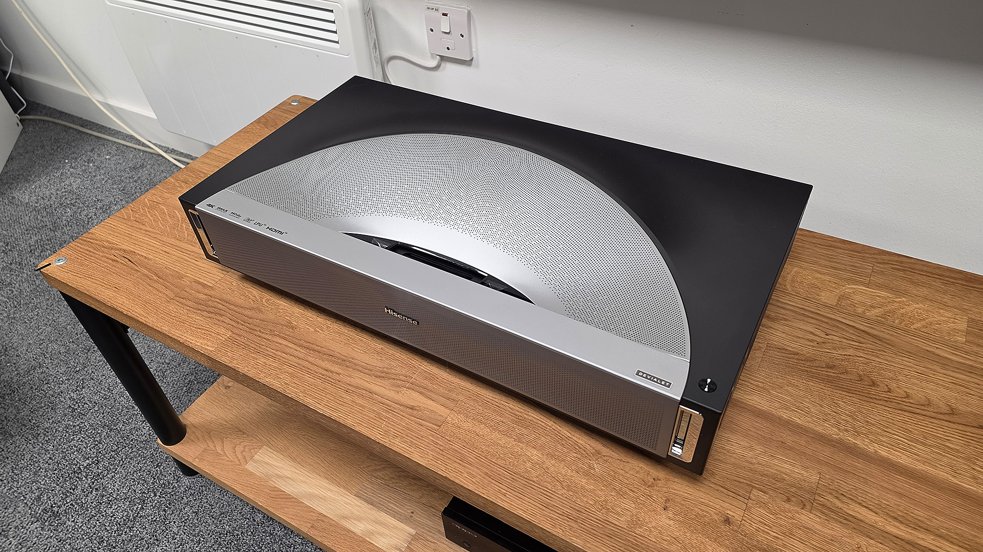 Hisense PX4 Pro UST projector on wooden AV rack