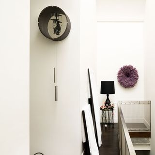 tic tac clock on white wall and wooden flooring