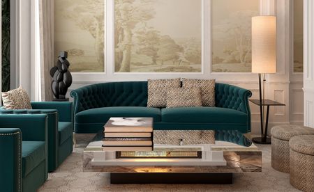 A hotel sitting area with green chairs, a green sofa, a mirror topped coffee table, a floor lamp, round ottomans and tree drawings on the walls.