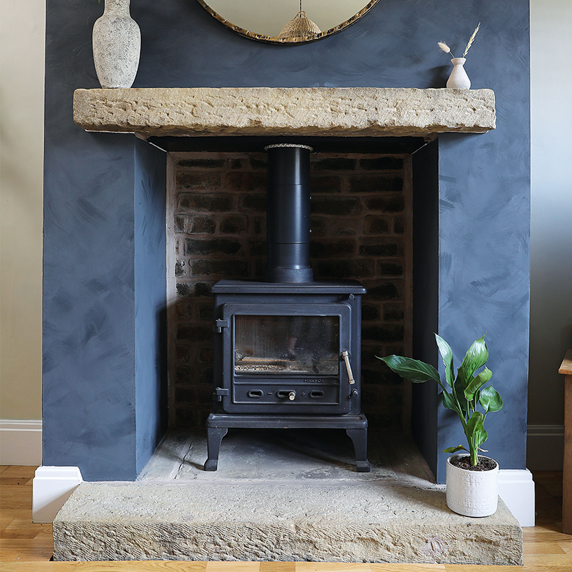 fireplace with woodburner and stone hearth
