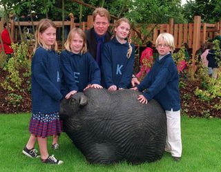 Kitty, Eliza, Amelia and Louis Spencer posing in front of a stone animal with father Earl Spencer at the Diana Memorial Playground in 2000.