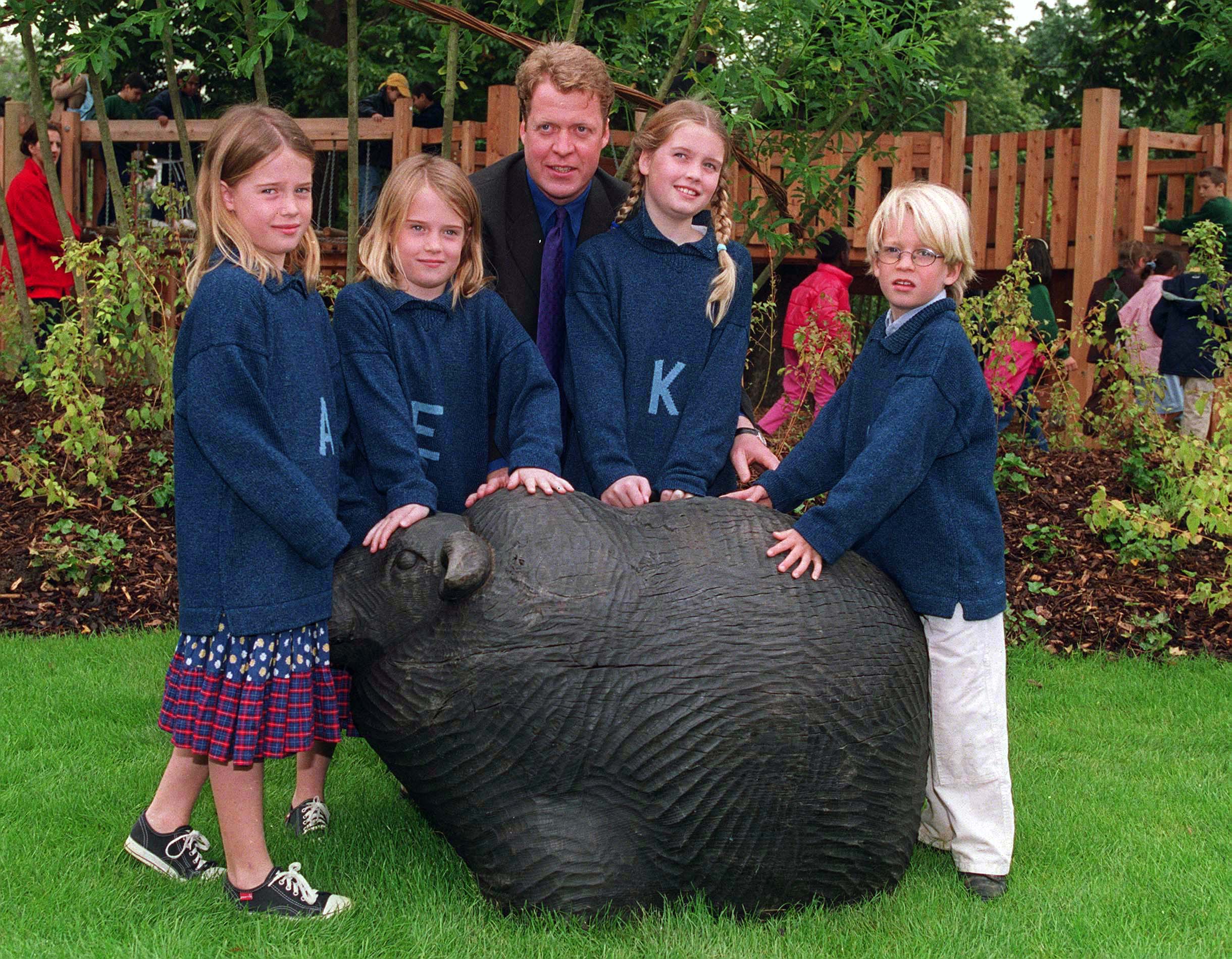 Kitty, Eliza, Amelia and Louis Spencer posing in front of a stone animal with father Earl Spencer at the Diana Memorial Playground in 2000.