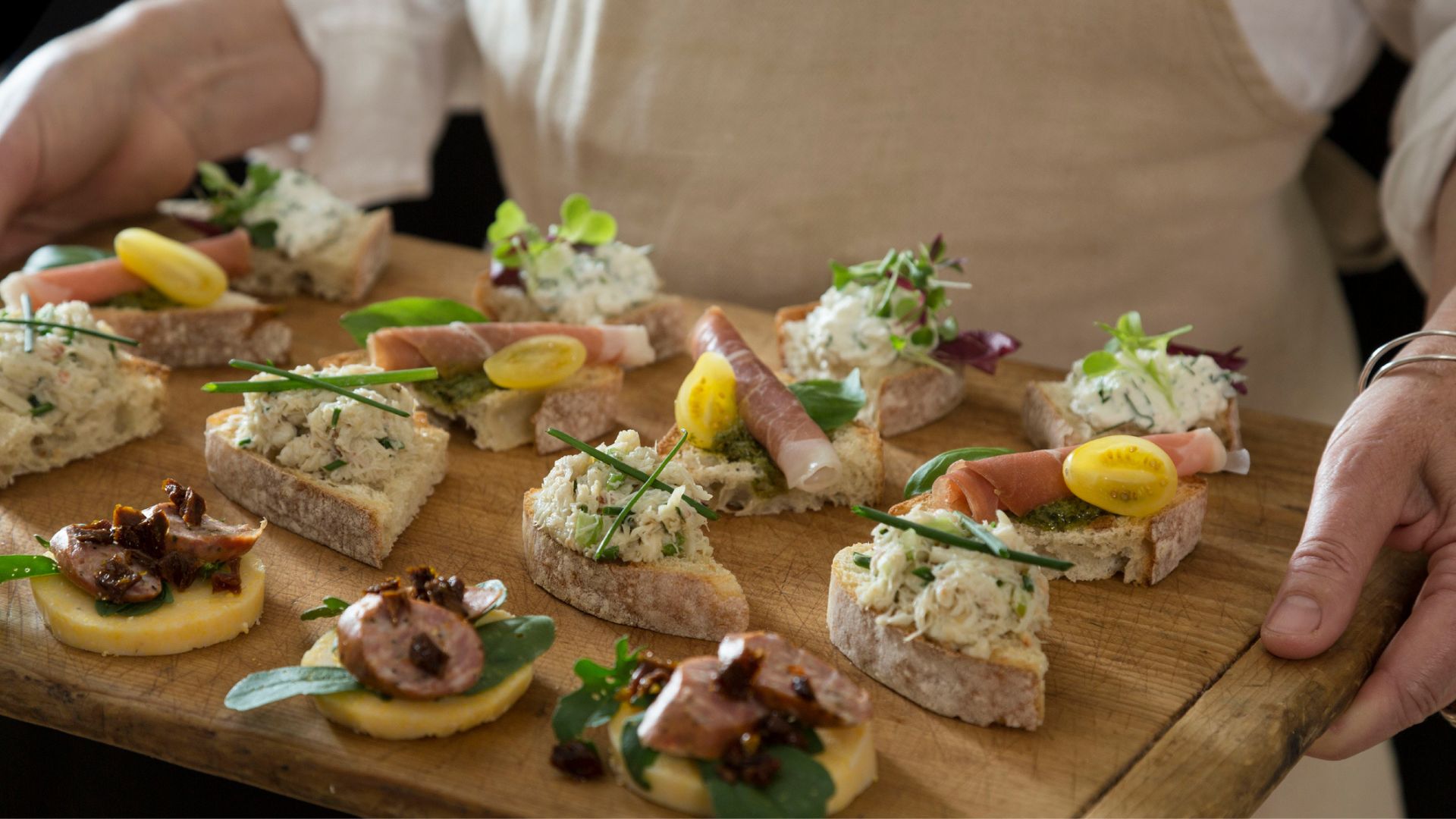 A lady holds a board of Venetian cicchetti