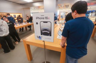 Customers experience an AI smartphone iPhone 16e at an Apple store in Shanghai, China