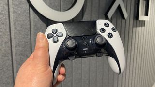 DualSense Edge controller being held up in front of the PlayStation logo