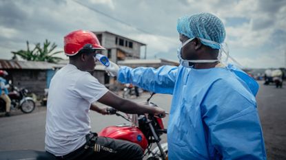 A health worker checks a man&rsquo;s temperature to screen for Ebola in the Democratic Republic of the Congo.
