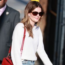 Meghann Fahy wearing a white shirt and red Loewe bag