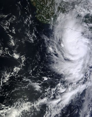 NASA's Terra satellite flew over Raymond on Oct. 20, 2013, at 2 p.m. EDT and saw clouds associated with Raymond's northern quadrant were streaming over mainland Mexico, despite the center being over open water.