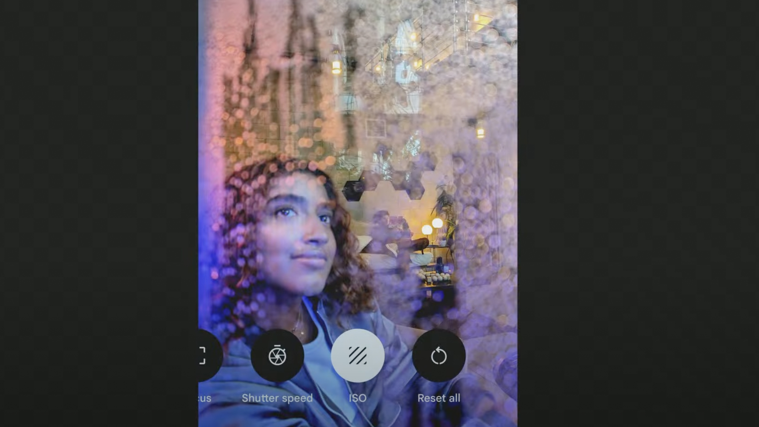 A woman looking out of a window behind a phone's camera controls