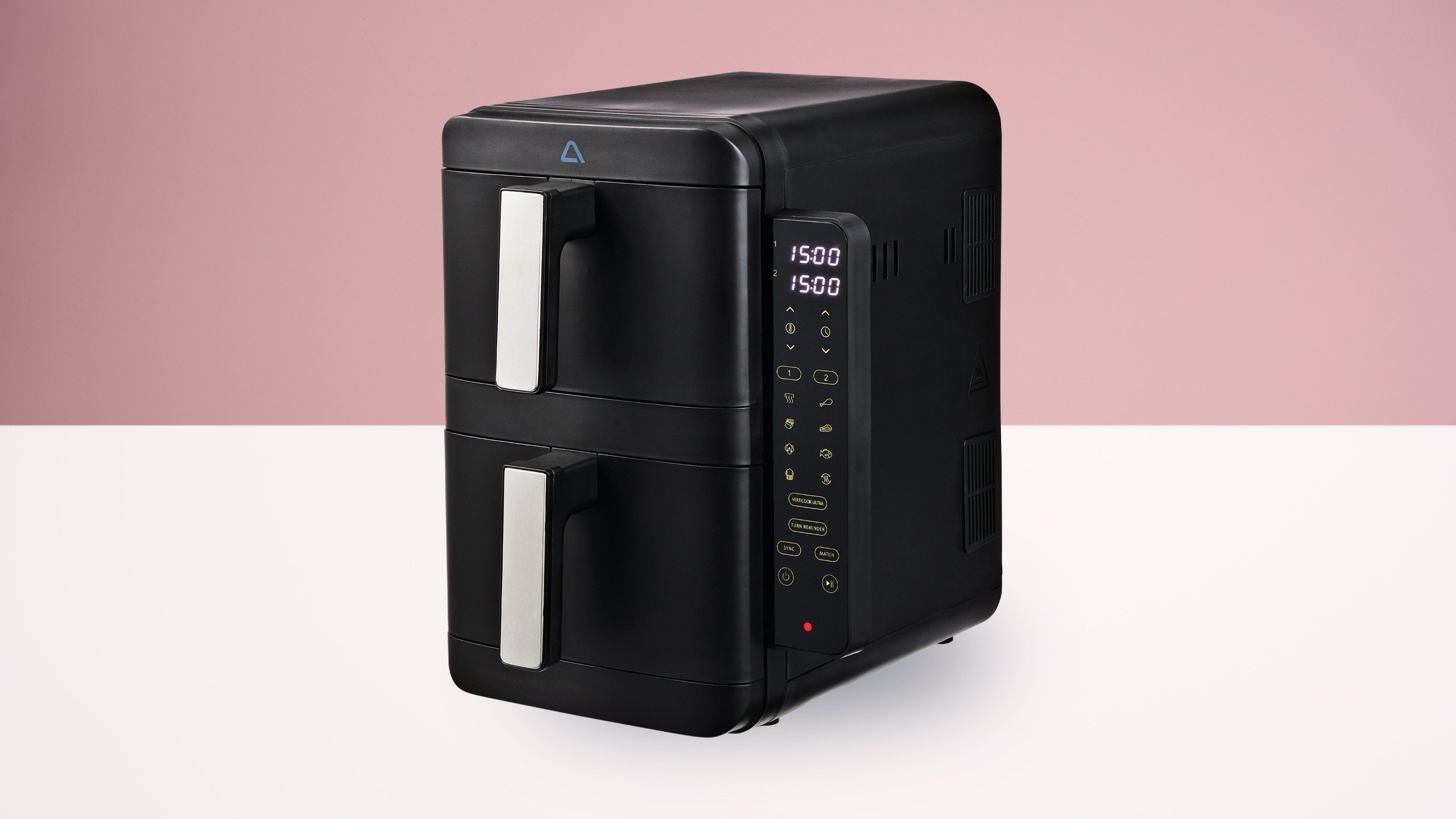 Aldi two-drawer air fryer on a white table against a pink wall