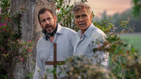Adam Sandler and George Clooney looking off in the distance in Jay Kelly.