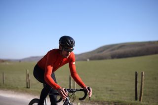 Image shows a rider cycling with hip pain.