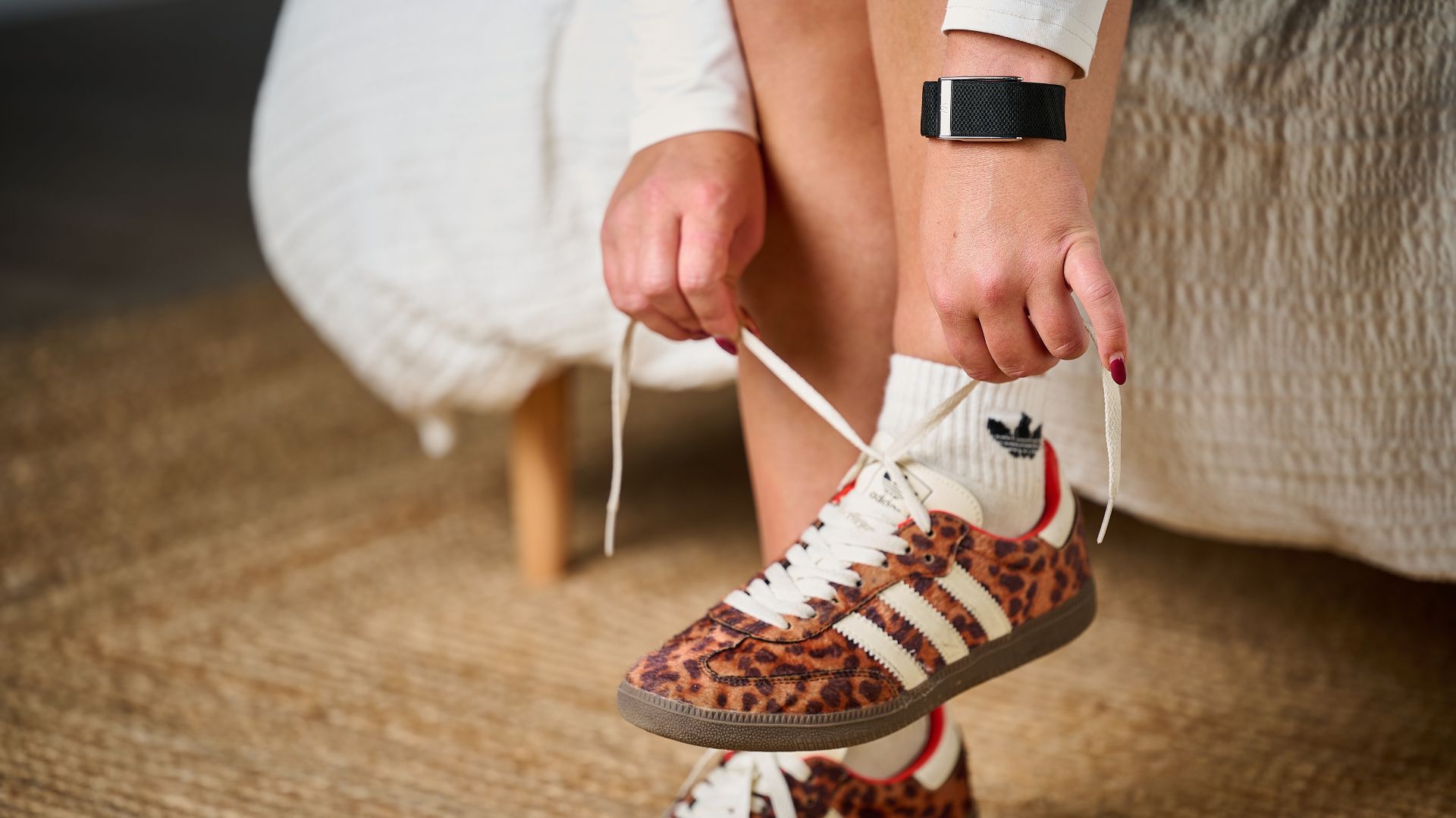 Tom's Guide's sleep tech tester sat on the edge of the bed tying trainer laces wearing the Whoop MG 