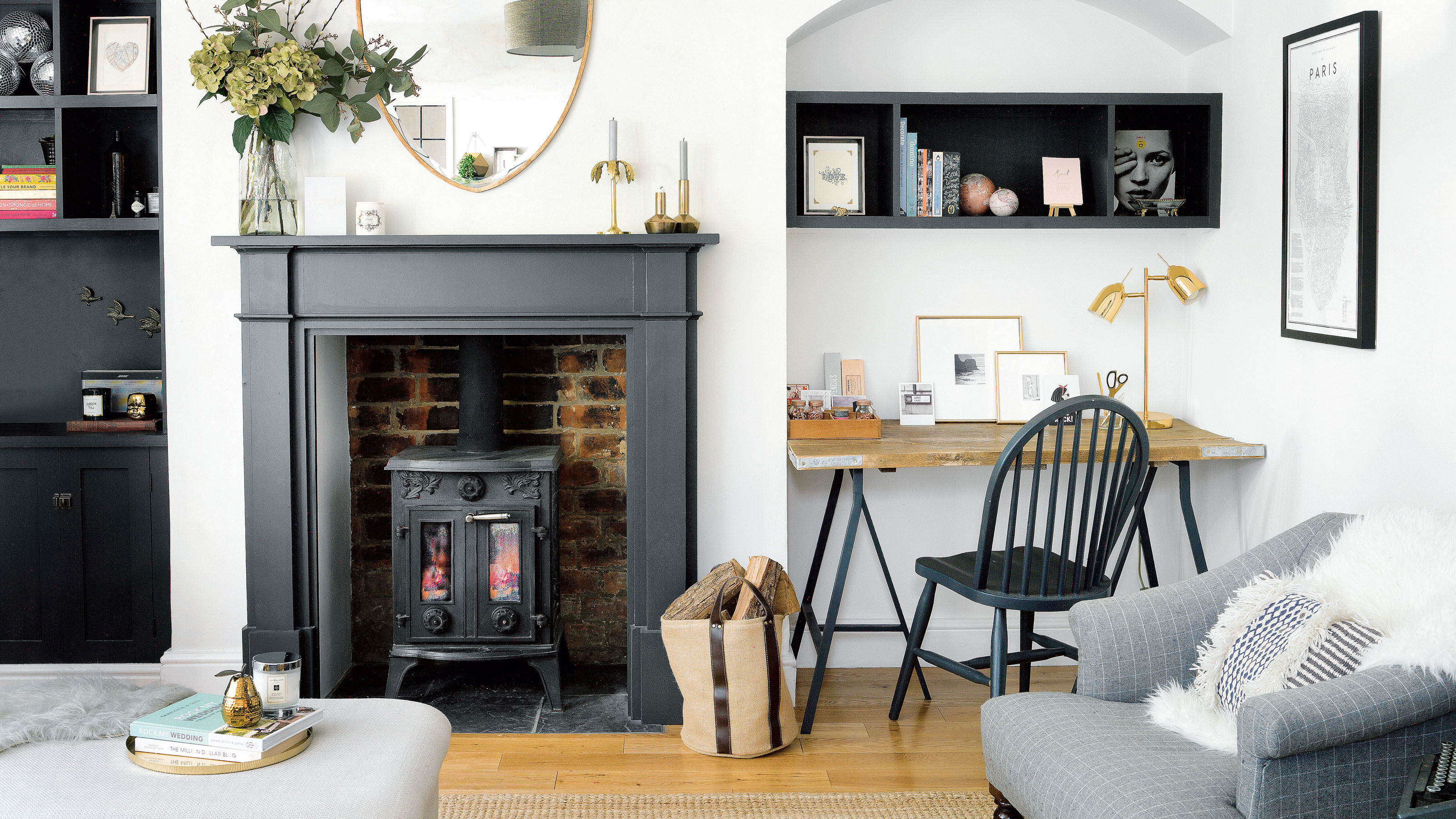 White living room with black fire place and trestle table desk