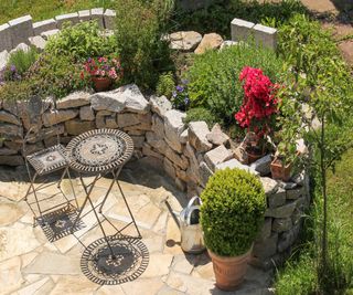 A stone raised bed built around a small seating area