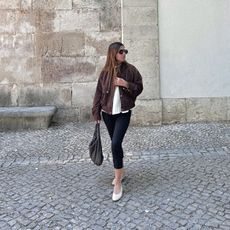 Woman wears capri leggings and almond toe flats.