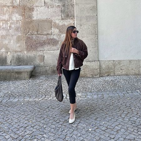 Woman wears capri leggings and almond toe flats.