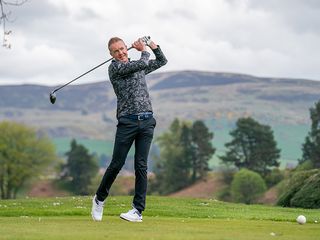 Fergus Bisset hitting a tee shot at the first