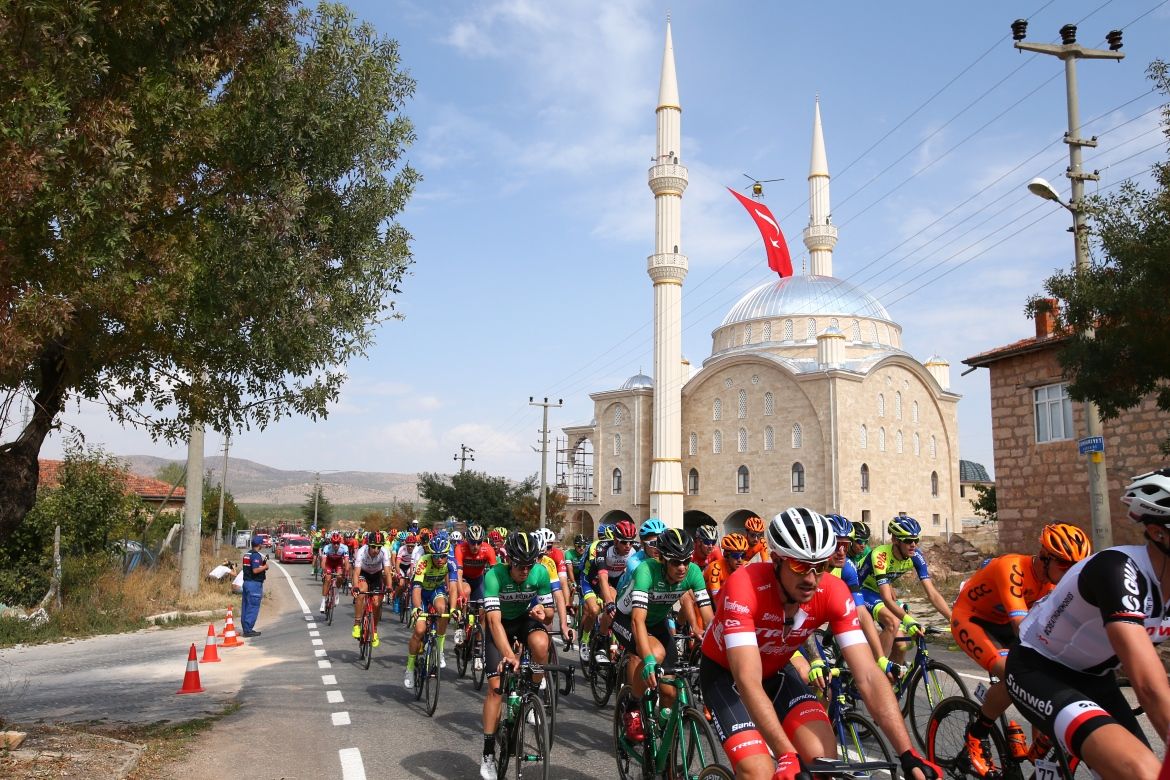 The riders pass by a mosque