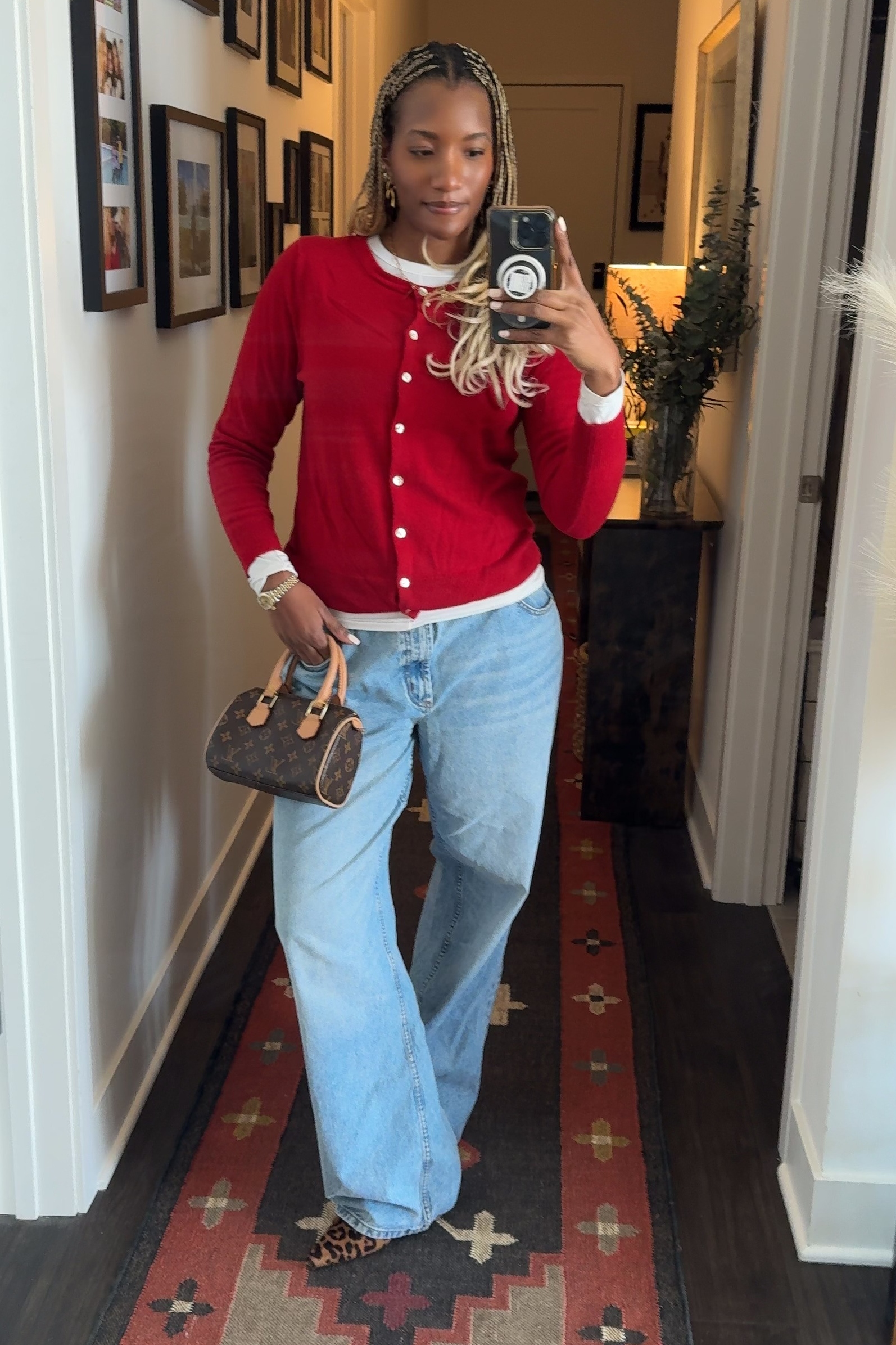 Danielle Prescod wearing a red sweater, jeans, and leopard-print flats