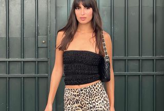 Woman in black top and leopard pants.