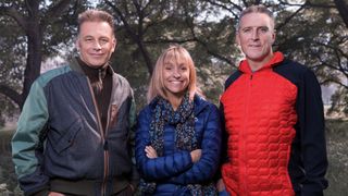 Chris Packham, Michaela Strachan and Iolo Williams wearing coats and standing outside by trees for Winterwatch 2025