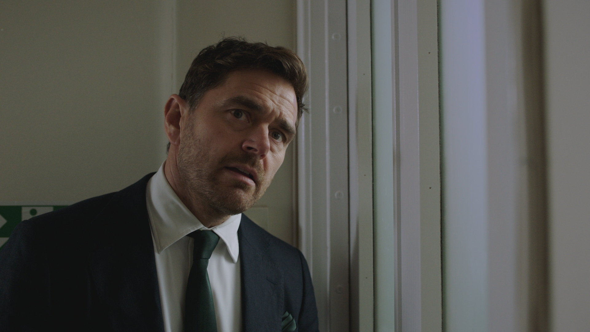 Iain Dean in his suit looking concerned.