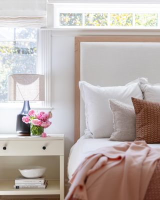 Neutral bedroom with flowers on the bedside table