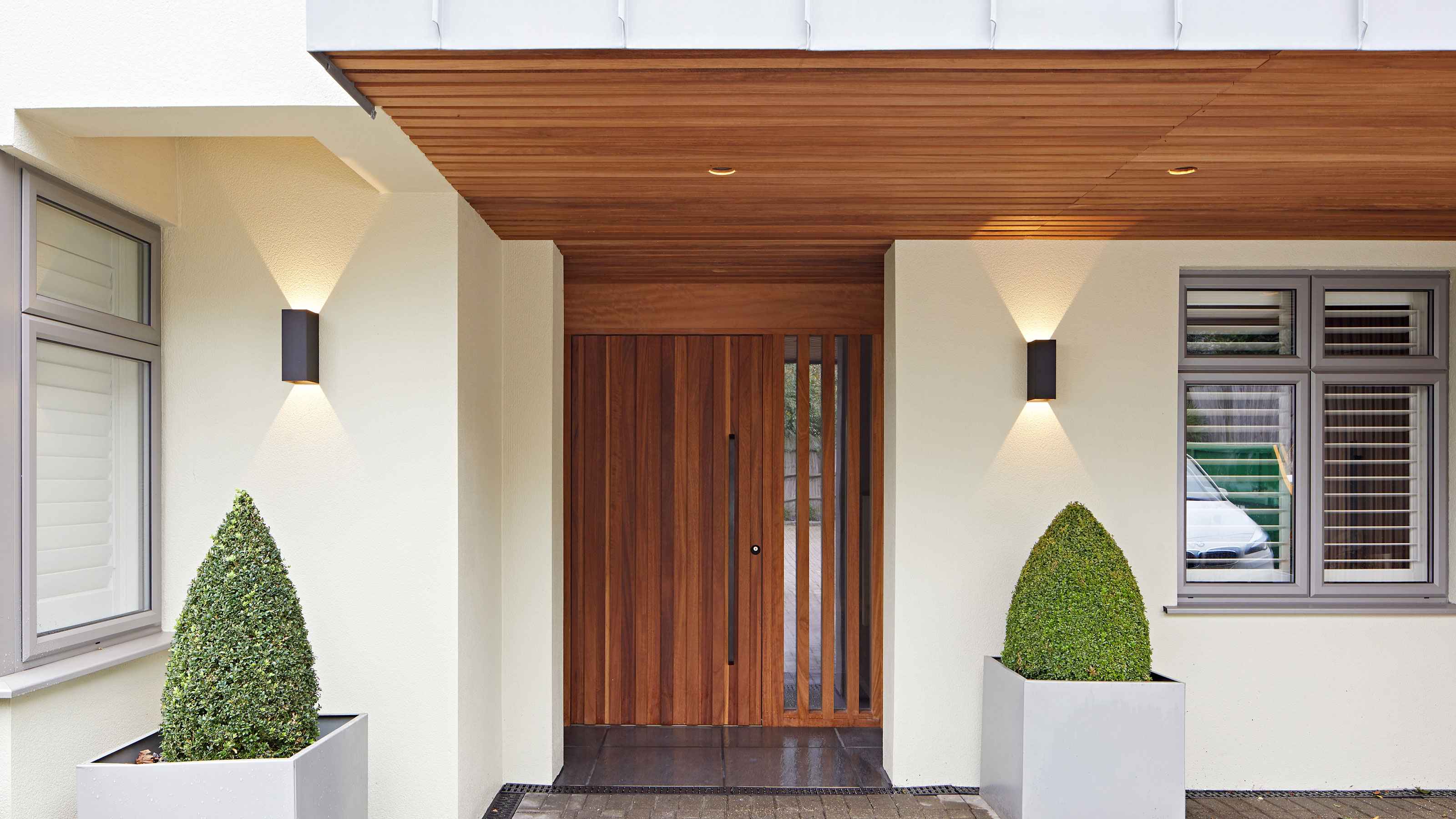 modern porch with contemporary wooden front door