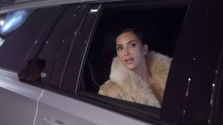 Kim Kardashian looking out the window of a limo in The Kardashians Season 7 trailer. 