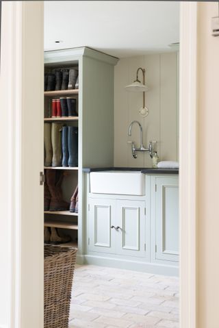 A mudroom with a deep sink and floor to ceiling storage for wellies