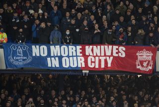 Liverpool and Everton fans come together in a banner against knife crime in the city in October 2001.