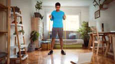 man uses long resistance band for exercise at home