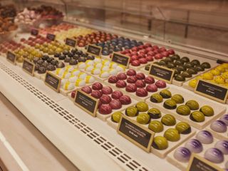 Multi-coloured chocolates inside harrods chocolate hall, preserved in climate controlled glass case