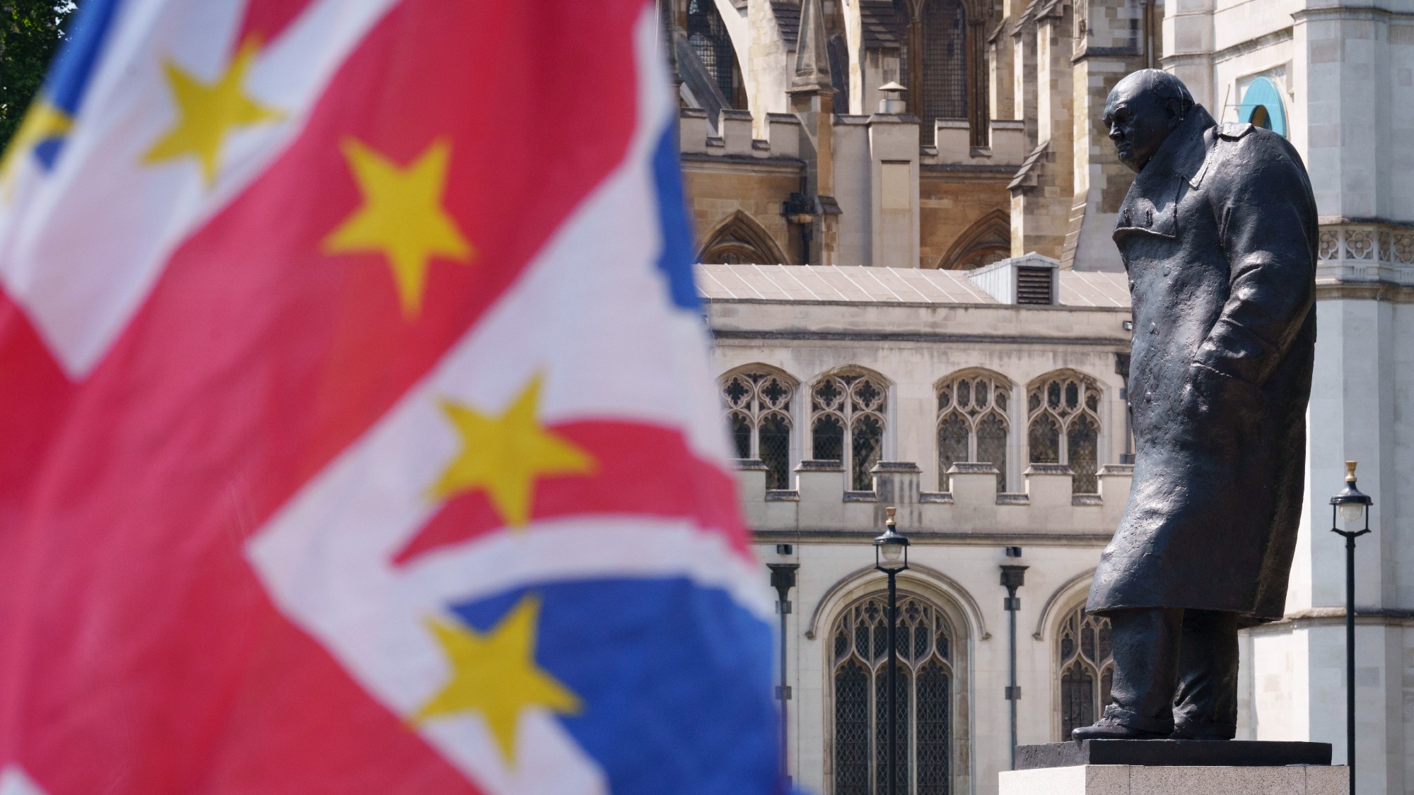 A Union Jack with EU stars waving beside a statue of Winston Churchill at the regular anti-Brexit protest in Westminster